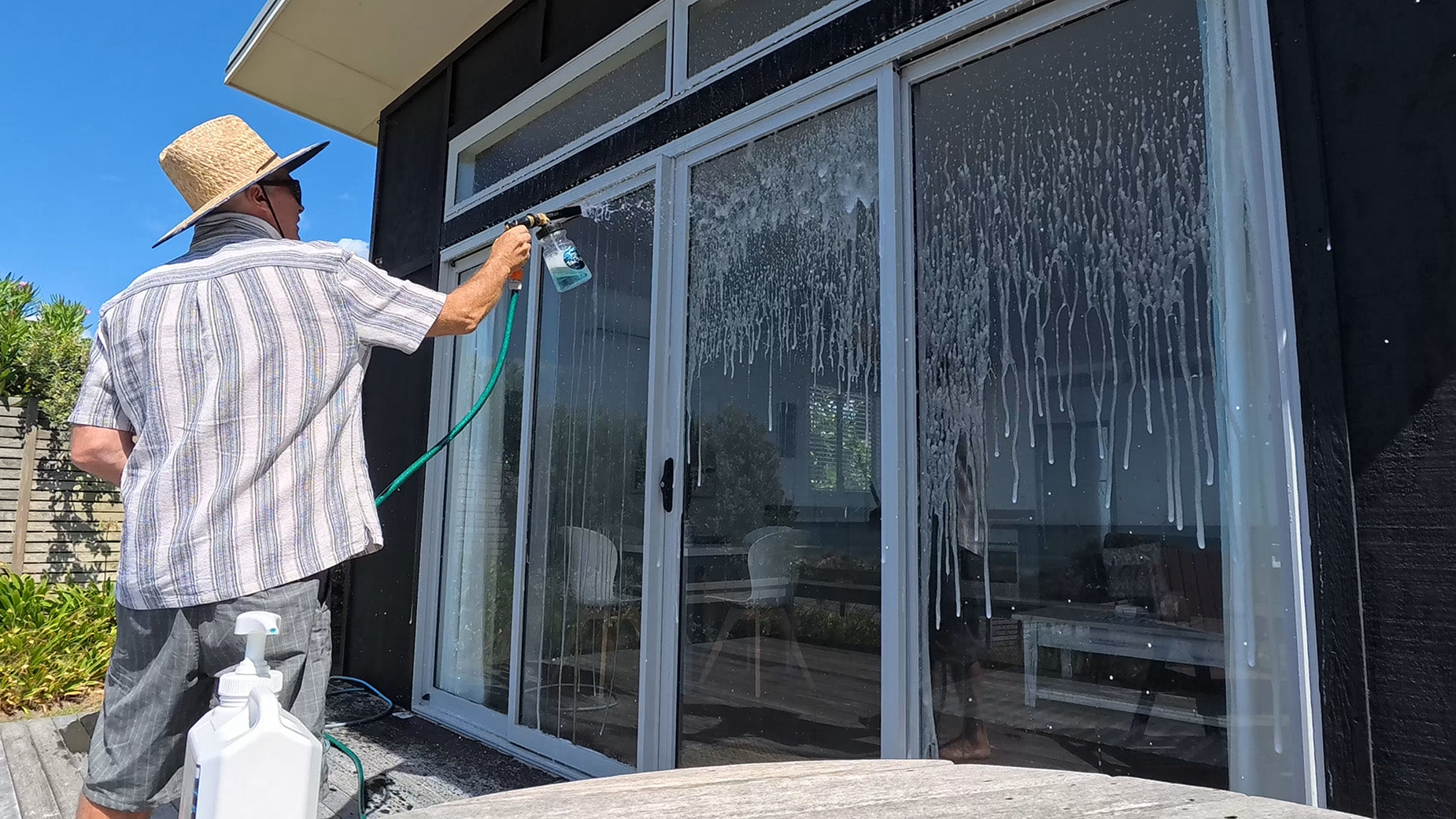 Salt-Shark being sprayed of a beach house removing salt off the windows.  smackmarine.com